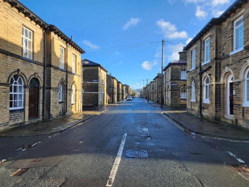 an empty street in an alley between brick buildings at Cosy 1BD Heritage Cottage in Saltaire, Shipley in Shipley