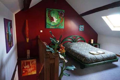 - une chambre avec un lit dans un mur rouge dans l'établissement Le Gîte de la Galerie d'Art, à Châtillon-sur-Seine