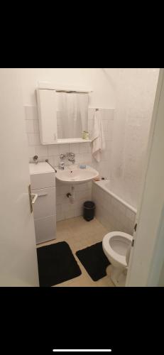 een witte badkamer met een wastafel en een toilet bij Apartman Ivan in Vršac