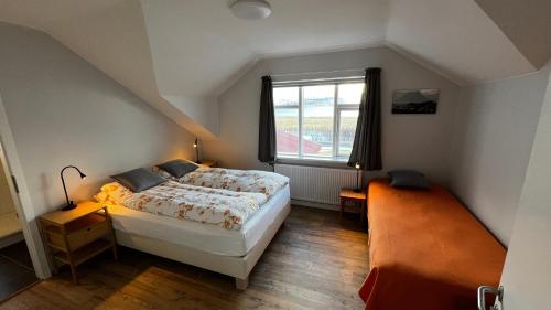 Rúm í herbergi á Sudur-Bár Guesthouse