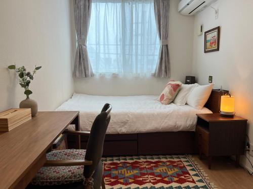 a bedroom with a desk and a bed with a window at Uhome Ikebukuro Villa 2 in Tokyo