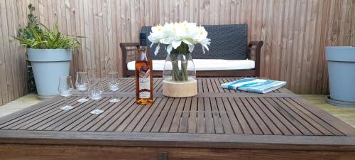 a table with a bottle of wine and a vase of flowers at Logis Hôtel de la Plage in La Cotinière