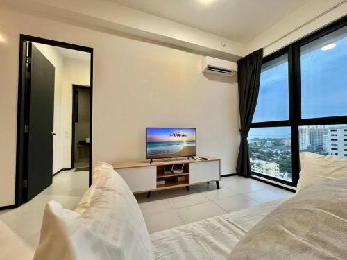 ein Schlafzimmer mit einem Bett und einem TV auf einem Tisch in der Unterkunft Urban Suite 3R2B 8Pax Georgetown in Jelutong