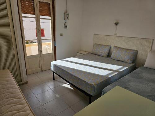 una camera con letto, divano e finestra di Residence Arlecchino a Lido Conchiglia