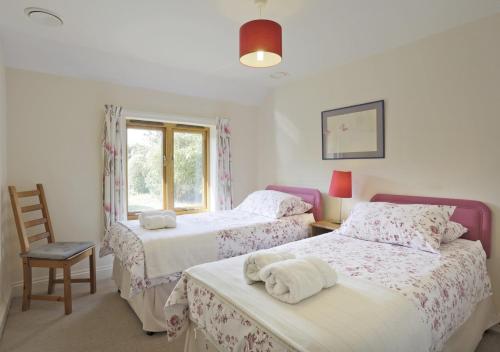 a bedroom with two beds and a window at Crofters in Blaxhall