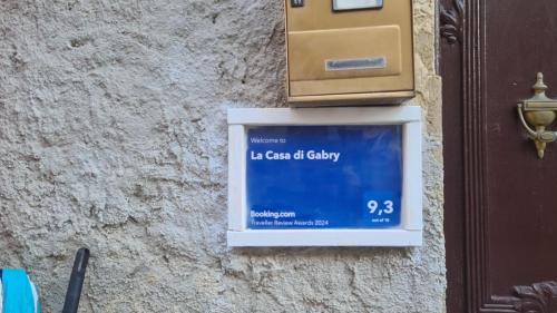 una señal en el costado de una pared con una caja en La Casa di Gabry, en Valledolmo