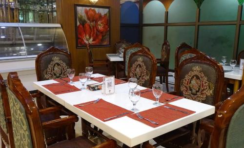 uma sala de jantar com uma mesa com copos de vinho em Hotel One Karachi em Carachi