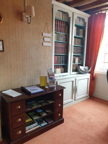a room with a dresser and a book shelf with books at LA GAUDINIERE in Lyons-la-Forêt