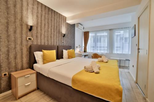 a bedroom with a large bed with yellow sheets at Garni House 46 Plus in Belgrade