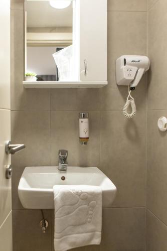 a bathroom with a white sink and a mirror at Garni House 46 Plus in Belgrade