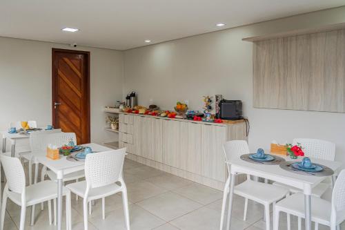 費爾南多迪諾羅尼亞的住宿－Pousada Tartarugas Marinhas，用餐室配有白色的桌子和白色的椅子