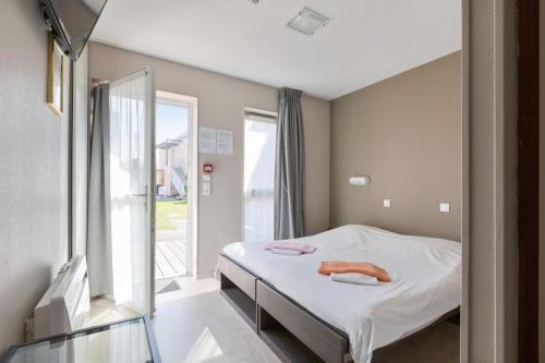 Habitación hospitalaria con cama y ventana en Les Tourelles Village de vacances, en Asnelles