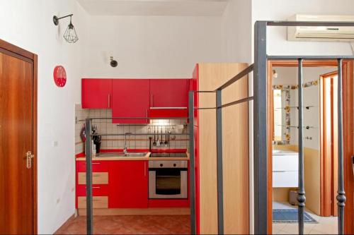 eine Küche mit roten Schränken in einem Zimmer in der Unterkunft CASA FELICITA' in Livorno