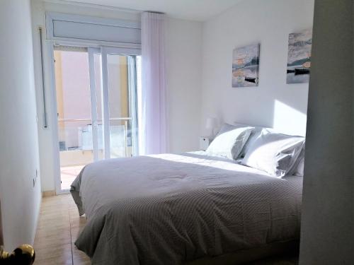 Habitación blanca con cama y ventana en Global Immo 3342 CARLAMAR, en Roses