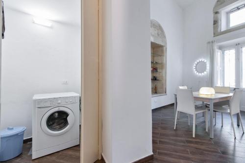 a kitchen and dining room with a washing machine at Suite dei Longobardi in Lecce