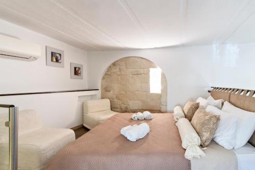 a bedroom with a large bed and a chair at Suite dei Longobardi in Lecce