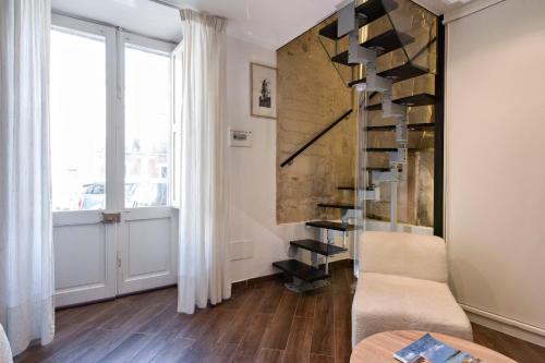a living room with a spiral staircase and a table at Suite dei Longobardi in Lecce