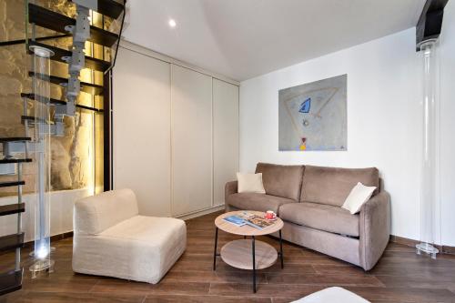 a living room with a couch and a chair at Suite dei Longobardi in Lecce
