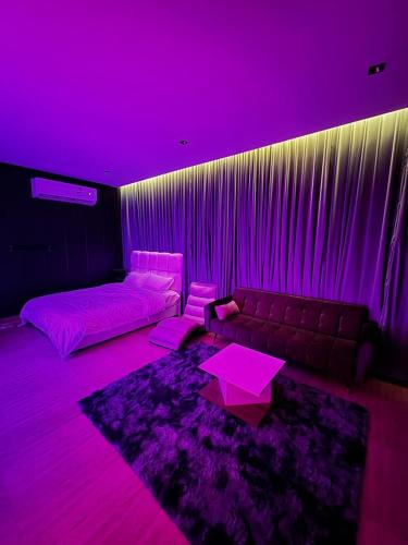 ein lila Zimmer mit einem Sofa und einem Tisch in der Unterkunft الرياض - حي قرطبة in Riad