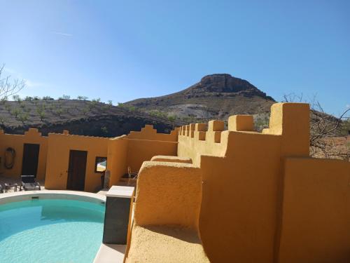 a resort with a pool and a mountain in the background at Casa rural los Cerezos in Albox
