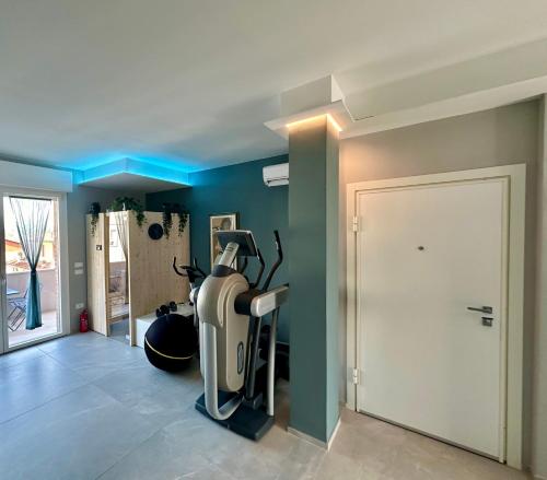 a room with a gym with a treadmill and a door at OliVia Rooms Sauna & Gym in Forlì