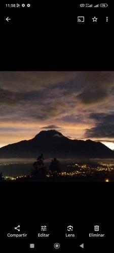 una imagen de una puesta de sol con una montaña en el fondo en JUYANIS HOSTAL, en Otavalo