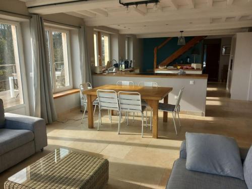 un salon avec une table et des chaises en bois dans l'établissement Maison de campagne la mer en horizon, à Tracy-sur-Mer
