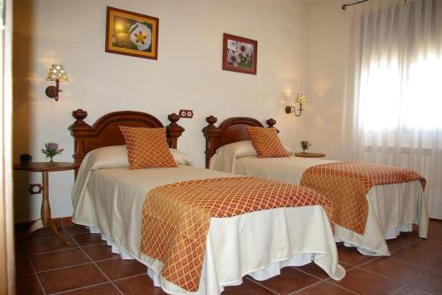 een slaapkamer met 2 bedden en een raam bij Casa Rural Cristina II in San Pablo de los Montes
