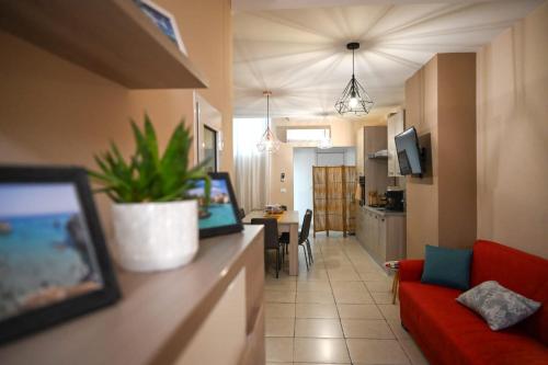 ein Wohnzimmer mit einem roten Sofa und einer Küche in der Unterkunft Il vecchio salone in Lecce