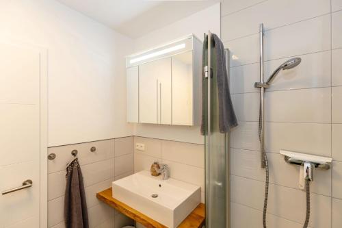 a white bathroom with a sink and a shower at Möwen-Butze 8103 Yachthafenresidenz in Kühlungsborn