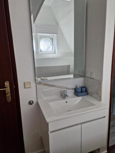 W łazience znajduje się umywalka i lustro. w obiekcie Casa do Miguel w mieście Foz do Arelho