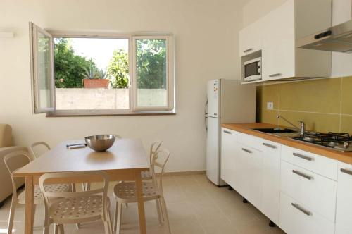 eine Küche mit einem Tisch, einem kleinen Tisch und Stühlen in der Unterkunft Hotel e Residence Il Faro Acciaroli in Acciaroli