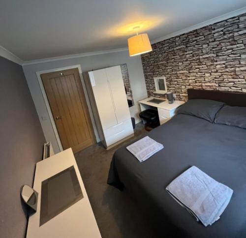 a bedroom with a bed and a brick wall at 5 Riverside Place Thurso. 2 bed, 2 bathrooms. in Thurso