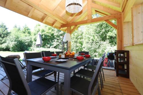 a table and chairs on a patio with a wooden ceiling at Chalet de l’Alpette in Valloire