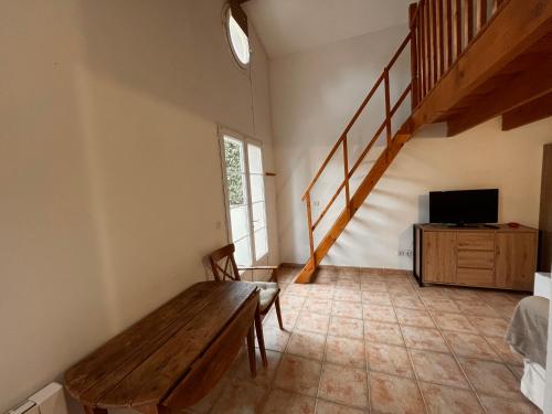 un salon avec un banc en bois et une télévision dans l'établissement LES VIEUX CABASSOLS VENELLES, à Venelles