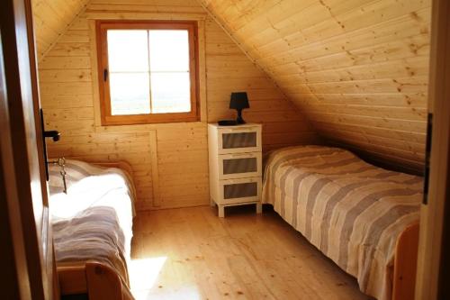 a bedroom with two beds in a log cabin at Piastogród 2 in Jarosławiec