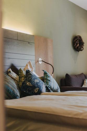 a bedroom with a bed with a lamp and pillows at Buchnas Landhotel Saarschleife in Mettlach