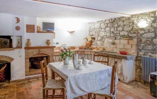 eine Küche mit einem Tisch und einem Kamin in der Unterkunft Lovely Apartment In Verni With Wifi in Verni
