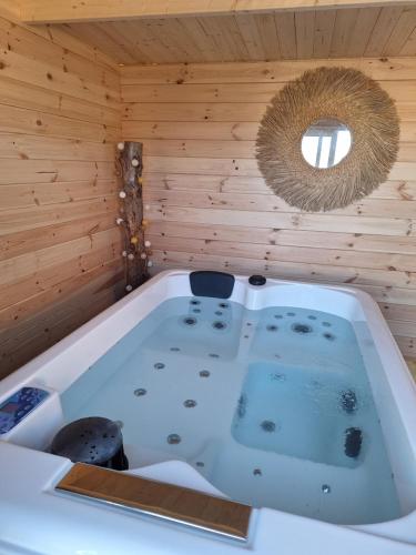 a sauna with a tub in a wooden wall at LAlexandrie in Régusse