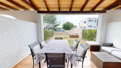 a patio with a table and chairs and a couch at Orquidea in Perelló