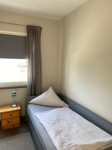 a small bedroom with a bed and a window at Budgethotel Stadtbett Wolfsburg in Wolfsburg