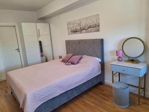 a bedroom with a bed with a mirror and a table at Apartment Teodo magico in Tivat