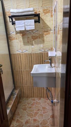 a bathroom with a sink and a mirror and towels at My5 Hotel in Kumasi