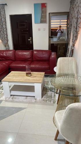 a living room with a red couch and a coffee table at My5 Hotel in Kumasi