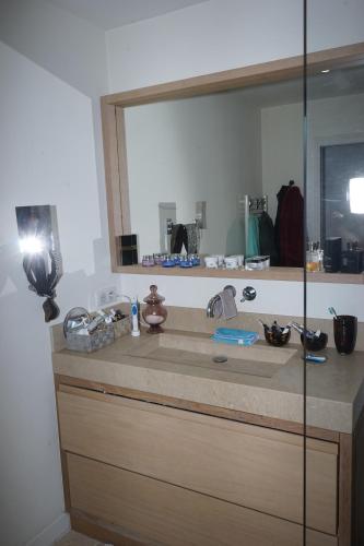 a bathroom with a sink with a large mirror at Villa les Cades in Sainte-Maxime
