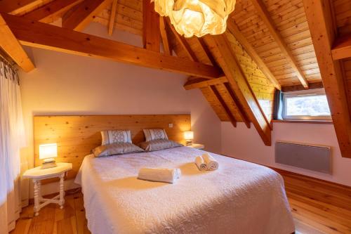 een slaapkamer met een bed met twee handdoeken erop bij Gîte Le Bédat in Ayzac-Ost