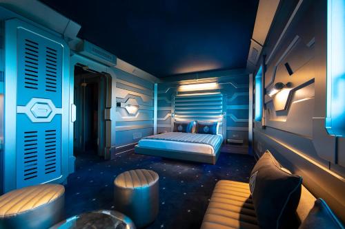 a blue bedroom with a bed and a table at Hôtel Station Cosmos in Chasseneuil-du-Poitou