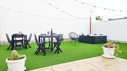 a patio with a table and chairs on grass at Stabile Hospitality in Trapani