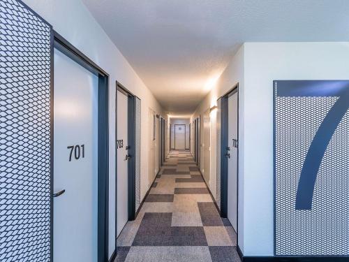 um corredor com uma fila de portas e um piso de azulejo em Hotel ibis Bragança em Brangança