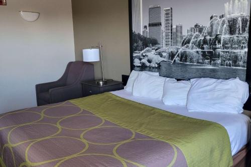 a hotel room with a large bed and a fountain at Super 8 by Wyndham Aurora/Naperville Area in Aurora